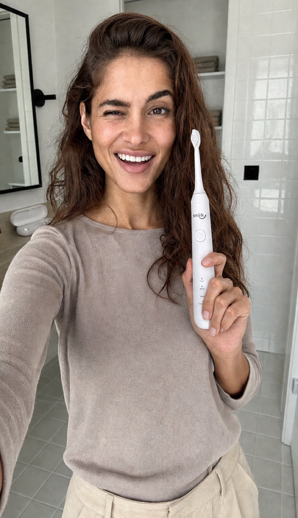 A happy Smirk customer holding the sonic toothbrush